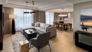 Een moderne woonkamer met een modulaire bank, een salontafel en een eethoek met een tafel en stoelen.