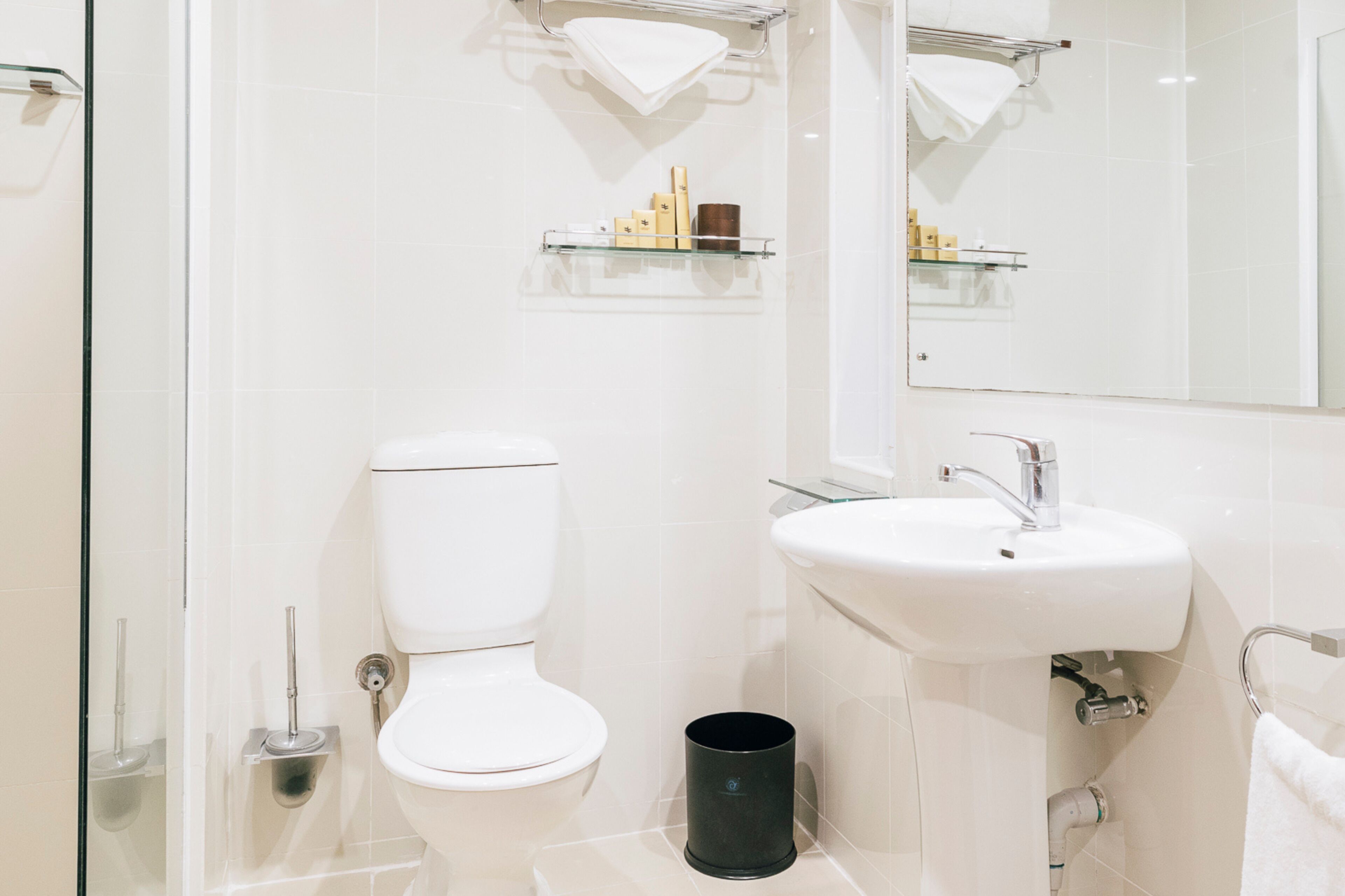 Ein modernes Badezimmer mit Toilette, Waschbecken und Glastablaren.