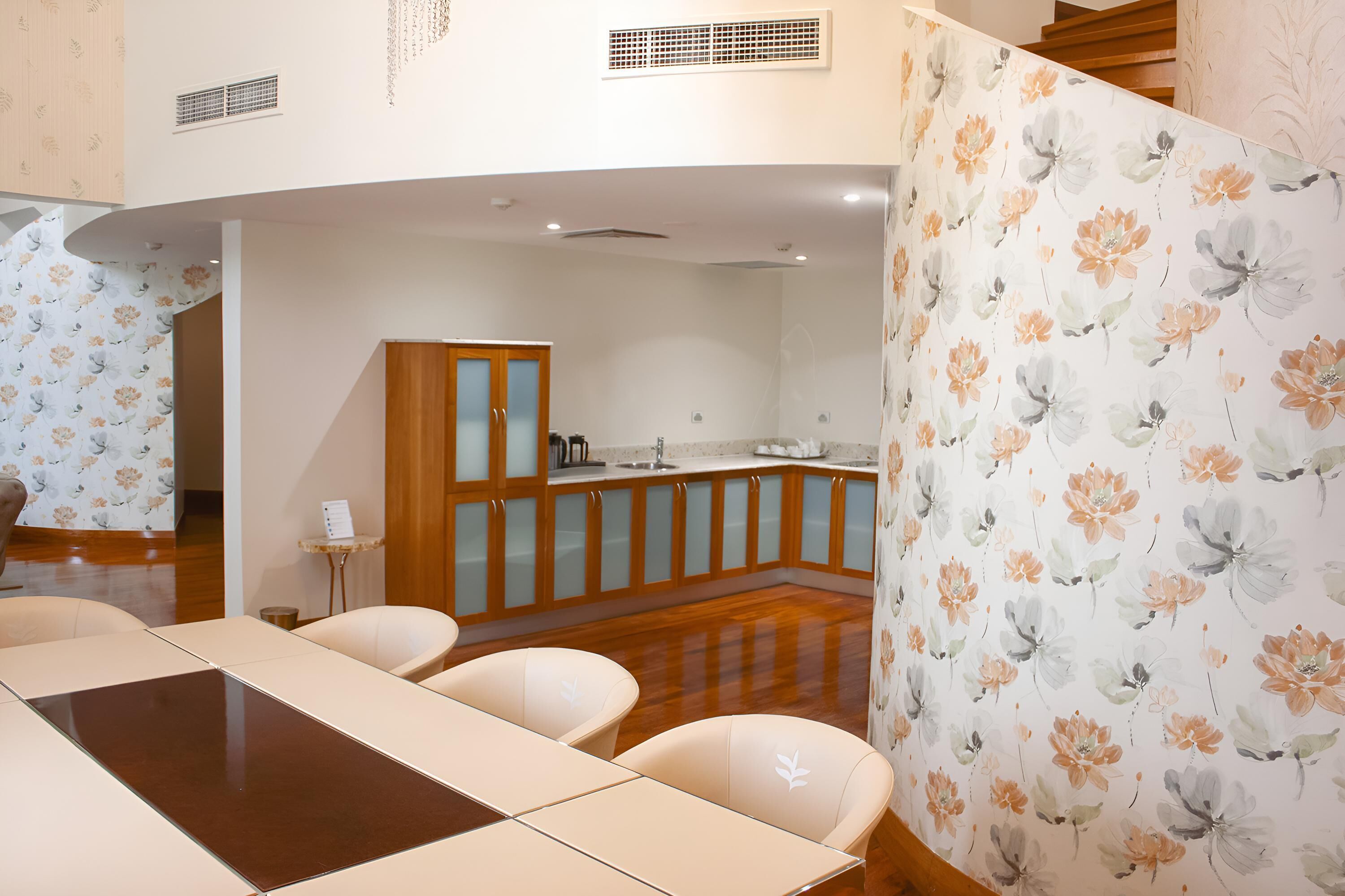 A modern kitchen with wooden cabinets, a central island, and a dining area with a table and chairs.