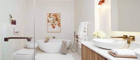 A modern bathroom with a freestanding bathtub, a large mirror, and a wooden vanity.