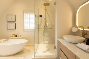 Villa | Badkamer | Een aparte badkuip en douche, een diep bad, een regendouche
