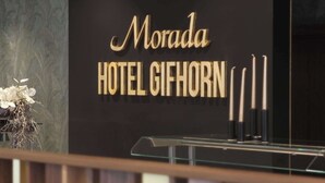Un letrero de hotel con el nombre 'Morada Hotel Gihorn' en letras doradas sobre un fondo negro.