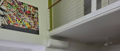 Een woonkamer met een bank, een klein houten tafeltje en een eethoek met stoelen.