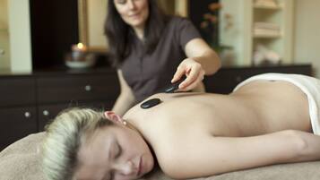 Experience a soothing massage in a serene space with a heated stone treatment.