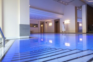 A spacious indoor swimming pool with a clear view of the ceiling and lighting fixtures.
