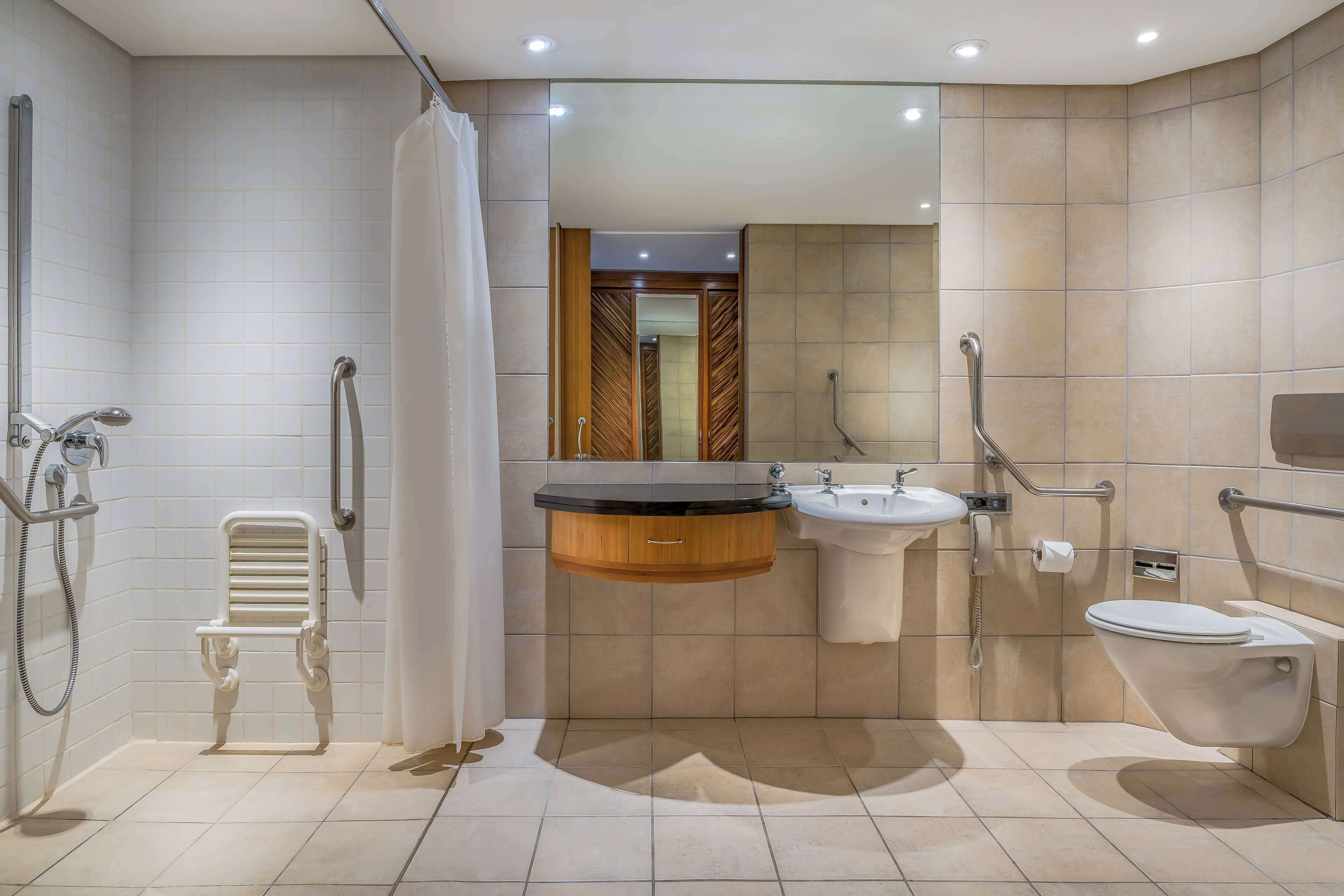 A modern bathroom with a shower, toilet, and sink.