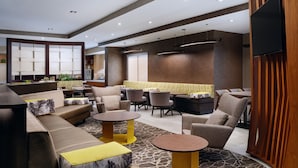 A modern lounge area with sofas, armchairs, and tables.