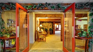 A lobby with a stone wall, wooden furniture, and a carpeted floor.
