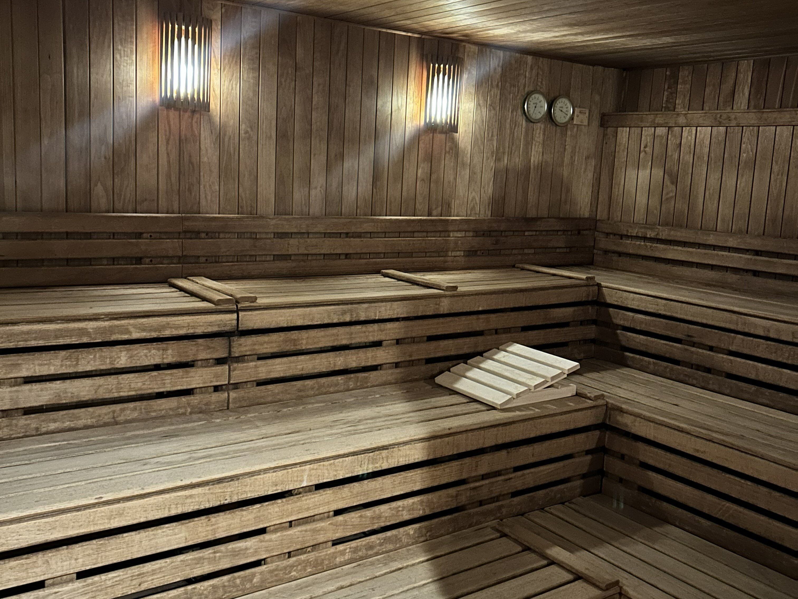 Una sauna con bancos de madera y paredes de listones.