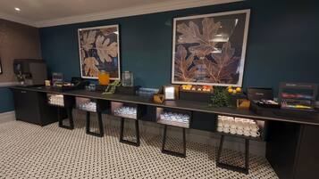 Un área de recepción con mostrador, obras de arte enmarcadas y una barra llena de botellas y copas.