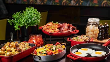 Una variedad de platos que incluyen patatas asadas, verduras salteadas y huevos en una sartén.