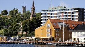 A waterfront hotel with a restaurant, a church, and a modern building in the background. - Thon Hotel Tønsberg Brygge (Tønsberg)