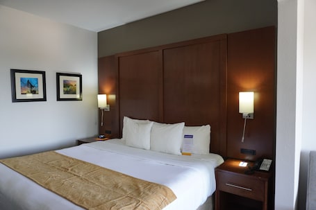 Escritorio, cortinas blackout y tabla de planchar con plancha