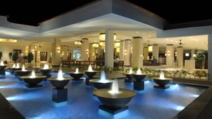 A hotel lobby with multiple water features and seating areas.