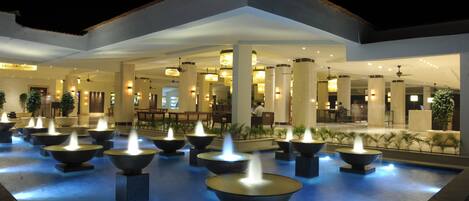 A hotel lobby with multiple water features and seating areas.