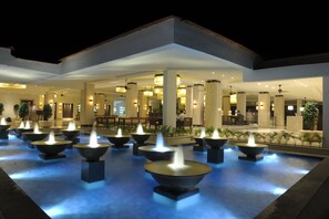 A hotel lobby with multiple water features and seating areas.