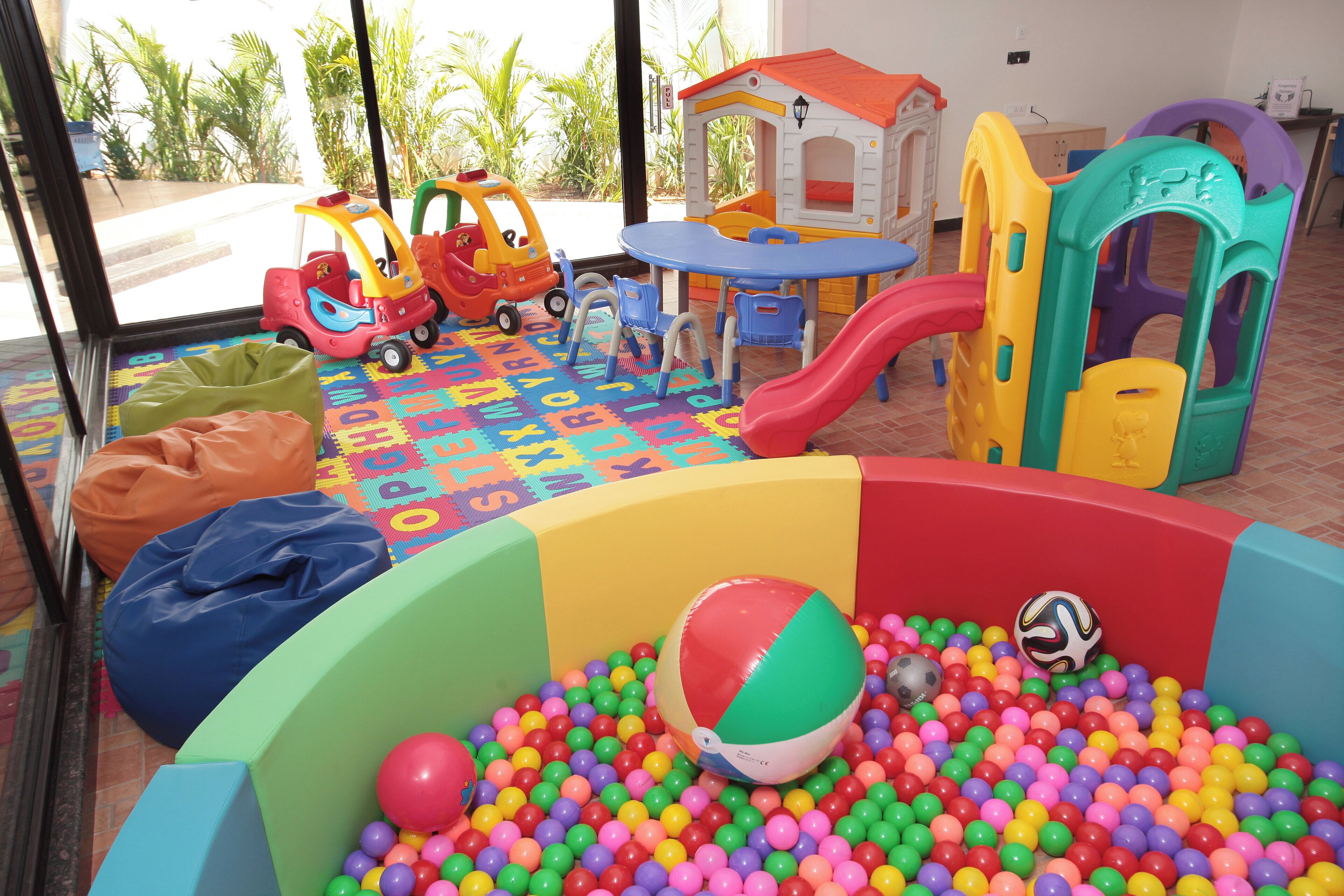 A children's play area with a ball pit, play structures, and a slide.