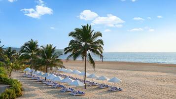 On the beach, white sand, sun-loungers, beach umbrellas