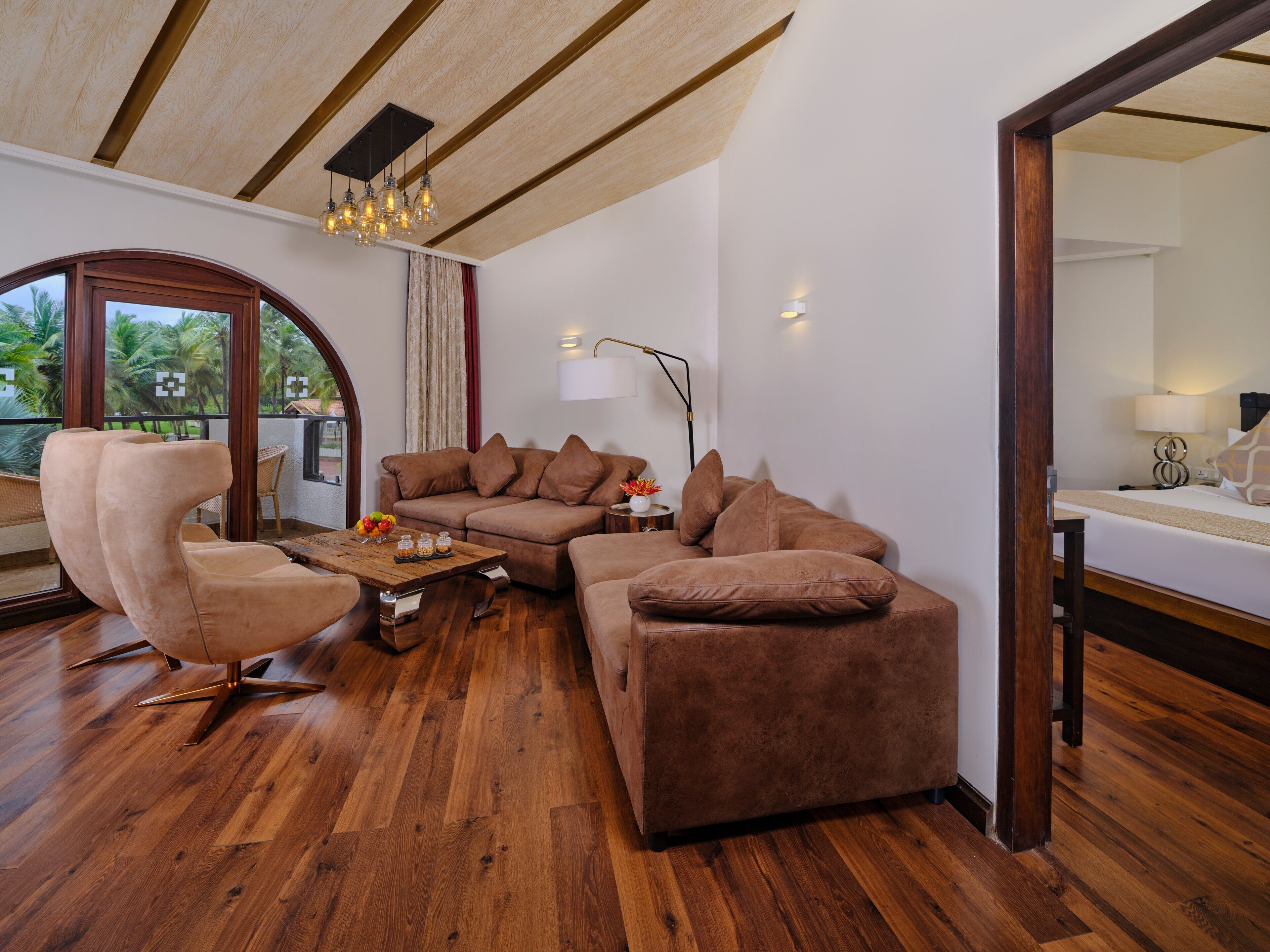 Una sala de estar moderna con un sofá modular, un sillón redondo y una mesa de centro de madera.