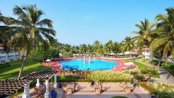 Resort com piscina central, áreas de estar ao ar livre e palmeiras.
