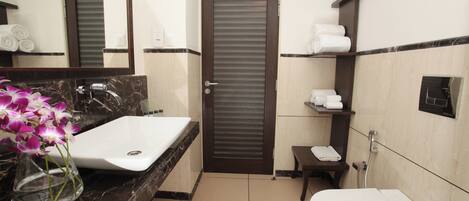 A bathroom with a marble sink, a toilet, a towel rack, and a mirror.