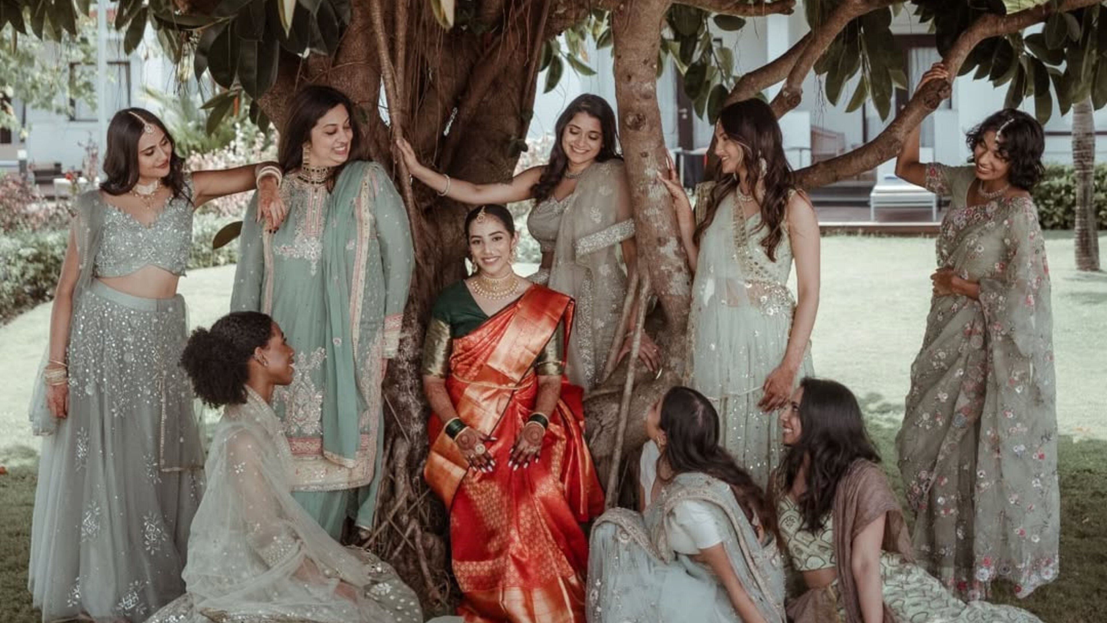 Un groupe de personnes s'est rassemblé sous un arbre, vêtues de costumes traditionnels.