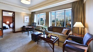 A hotel room with a city view, a sofa, a coffee table, and a desk with a lamp. - The Hongta Hotel, a Luxury Collection Hotel, Shanghai (Shanghai)
