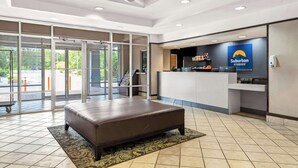 A modern reception area with a large desk, a sofa, and a glass door entrance.