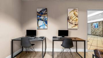 A modern office space with two desks, each with a computer and a chair.