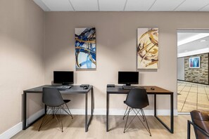 A modern office space with two desks, each with a computer and a chair. - Suburban Studios Orlando - Ocoee/Winter Garden (Ocoee)
