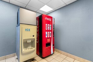 Máquina expendedora con logotipo de Coca-Cola y dispensador de hielo.