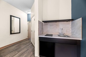 Un baño moderno con espejo, lavamanos y muebles oscuros.