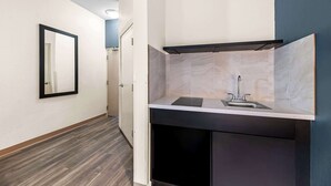A modern kitchen with a built-in stove, sink, and dark cabinetry.