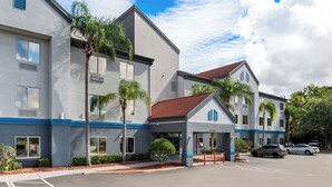 A modern hotel with a two-story structure, a covered entrance, and a parking area.