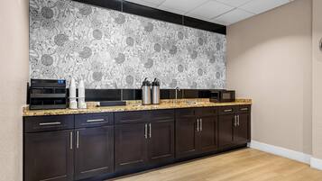 Una cocina moderna con armarios oscuros, encimera de granito y salpicadero con estampado floral.