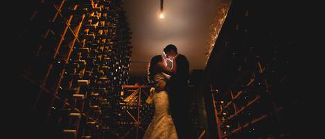 A couple embracing in a dimly lit room with a large, ornate chandelier.