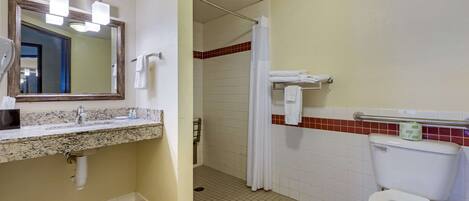 Une salle de bain avec un lavabo, un miroir et des toilettes.