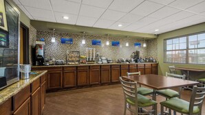 A restaurant with a counter, seating area, and a tiled backsplash.