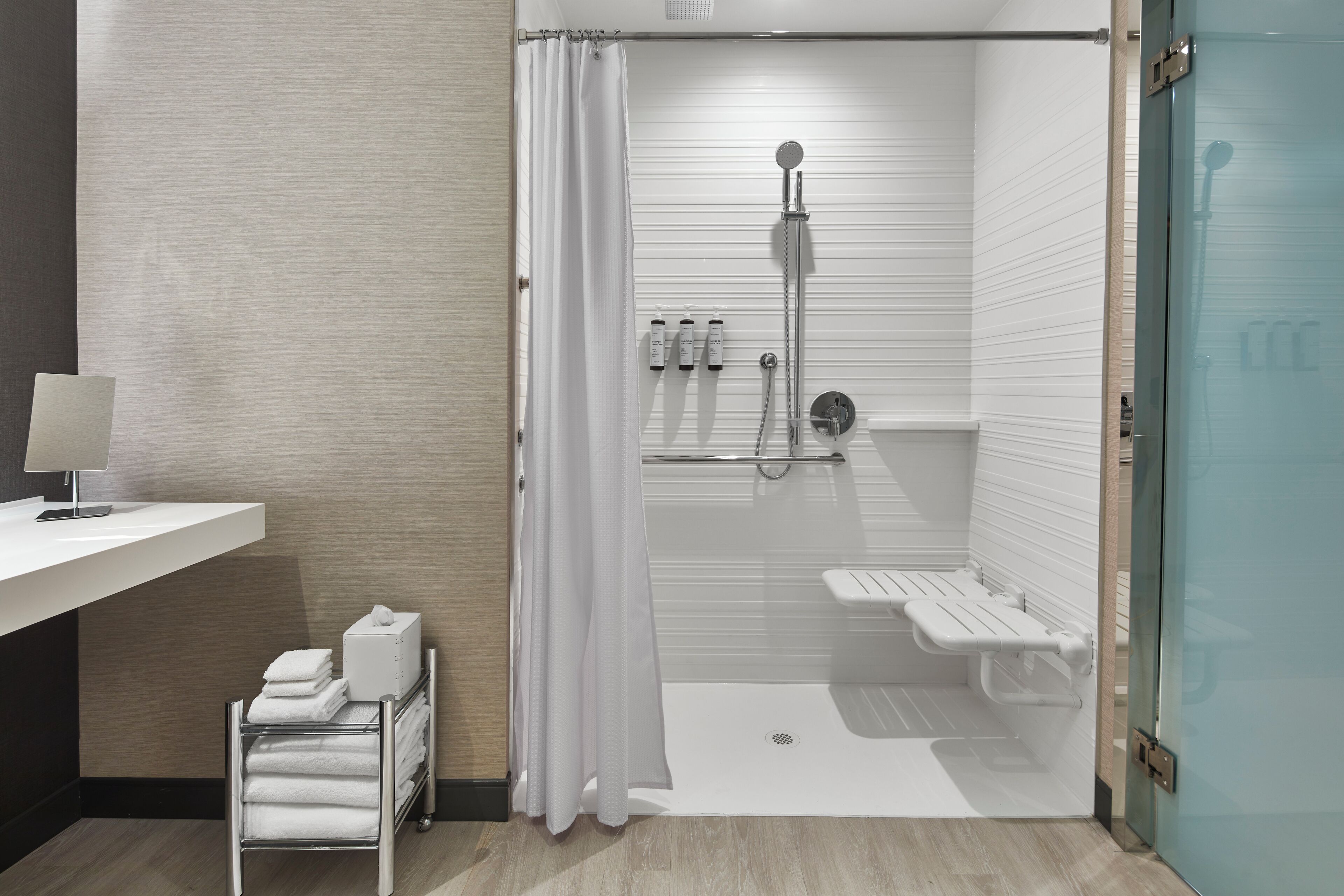 Un baño moderno con ducha, inodoro y lavamanos.