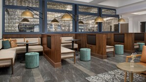Ein stilvoller Lounge-Bereich mit Sitzgelegenheiten, Tischen und dekorativer Beleuchtung.