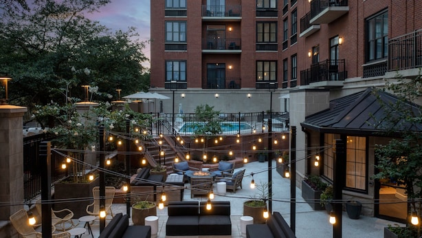 Eine Außenpatio-Terrasse mit Lichterketten, Sitzgelegenheiten und einem Pool.