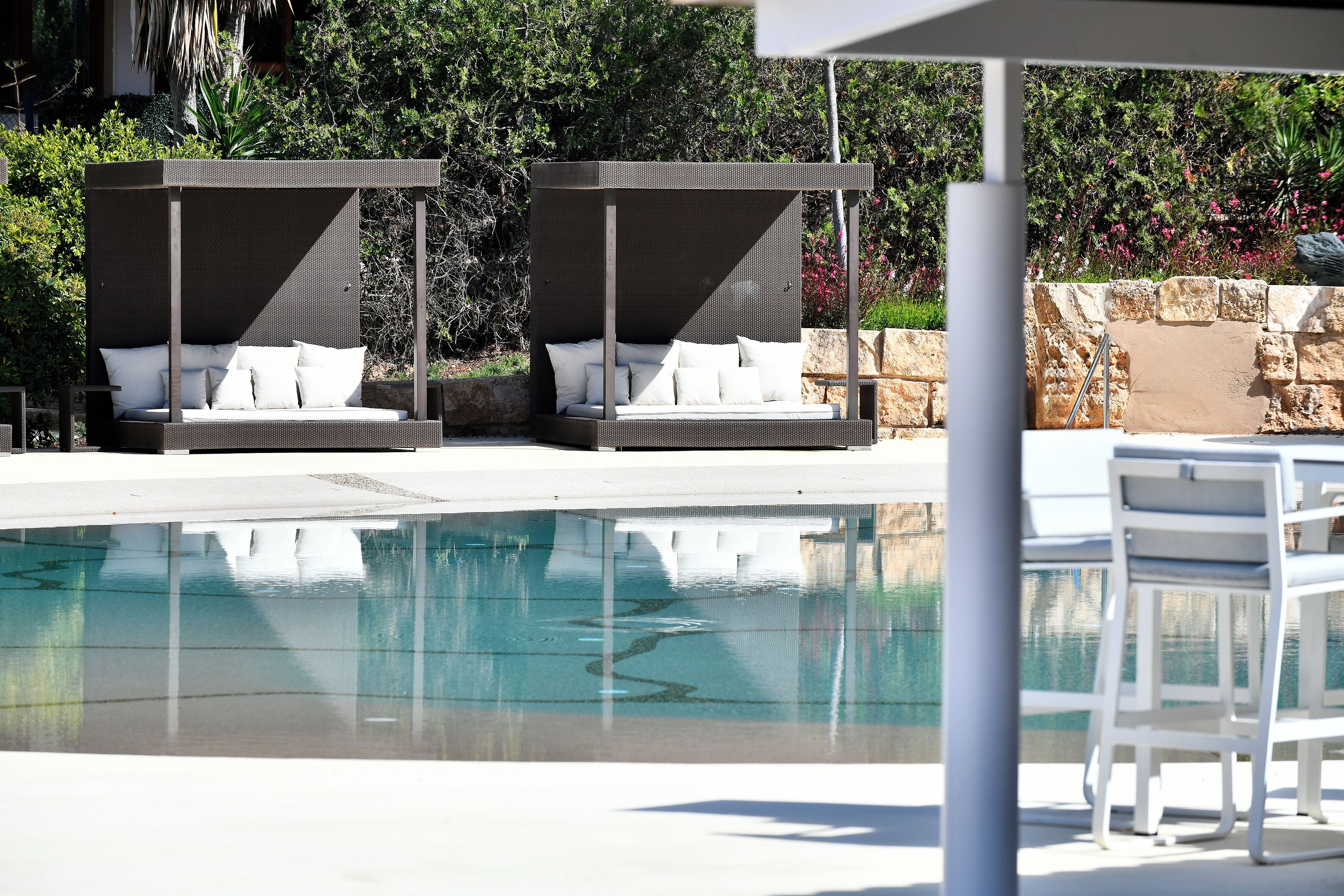 A pool area with two sun loungers and a table.