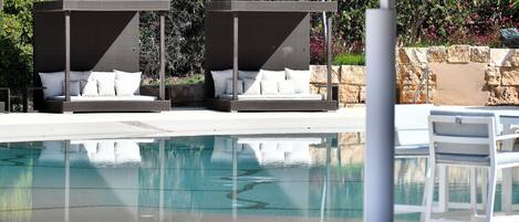 A pool area with two sun loungers and a table.