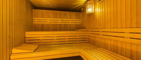 A sauna with wooden benches and a clock on the wall.