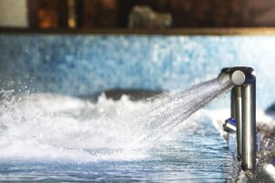 Primer plano de un caño vertiendo agua en una piscina.