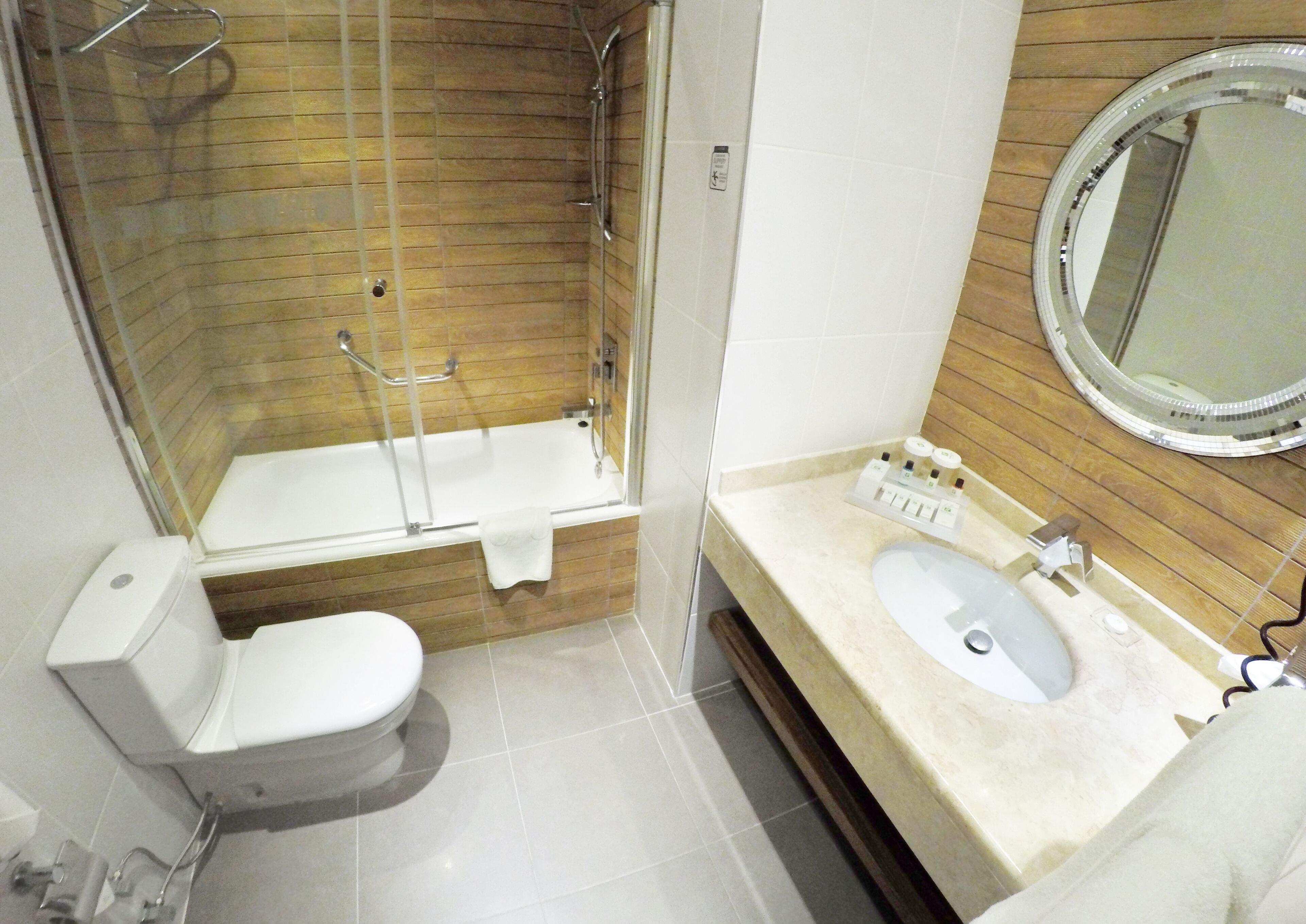 A bathroom with a shower, toilet, and sink.