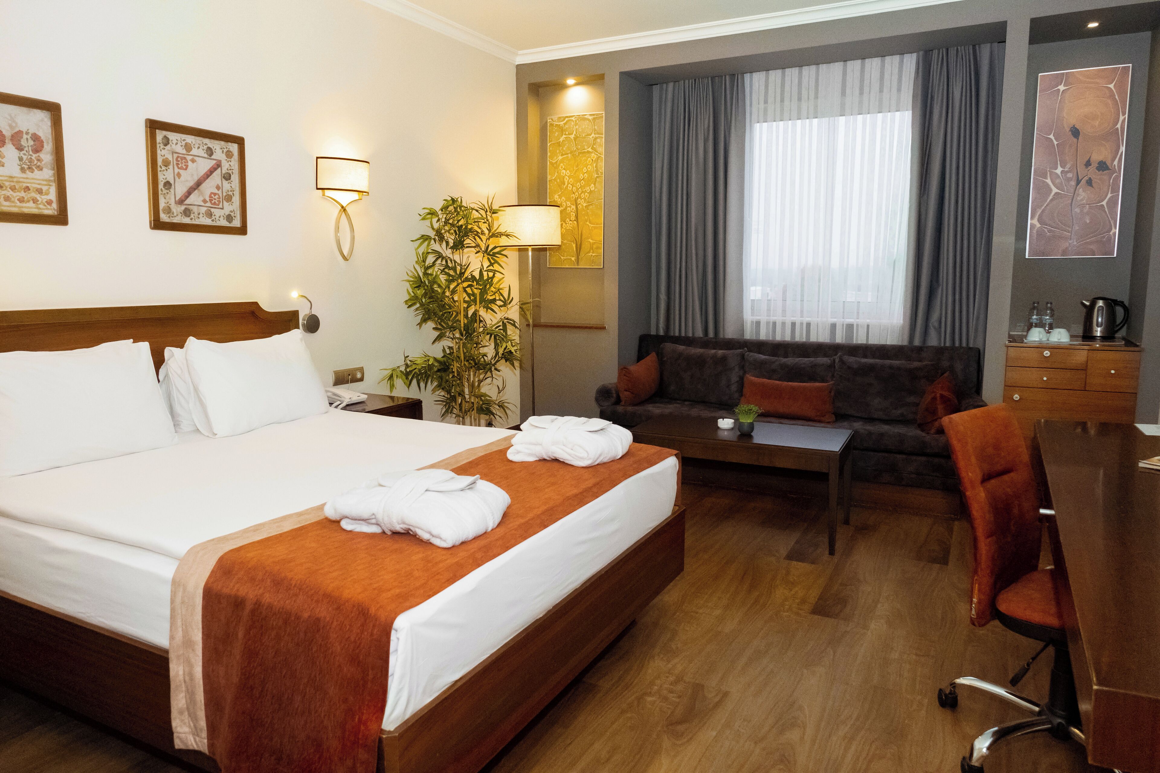 Une chambre d’hôtel avec un grand lit, un canapé, un bureau et une machine à café.