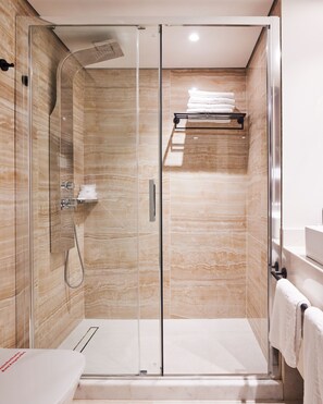 A modern bathroom with a glass-enclosed shower, a white sink, and a towel rack. - Hotel Mediterranean (Rhodes)