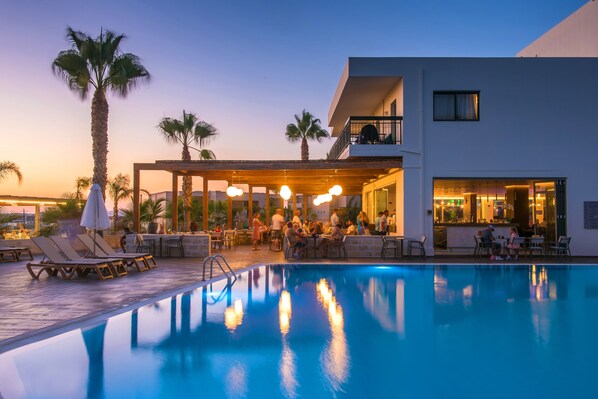 En säsongsöppen utomhuspool, parasoller och solstolar