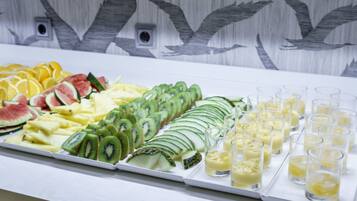 A buffet with various fruits and beverages.